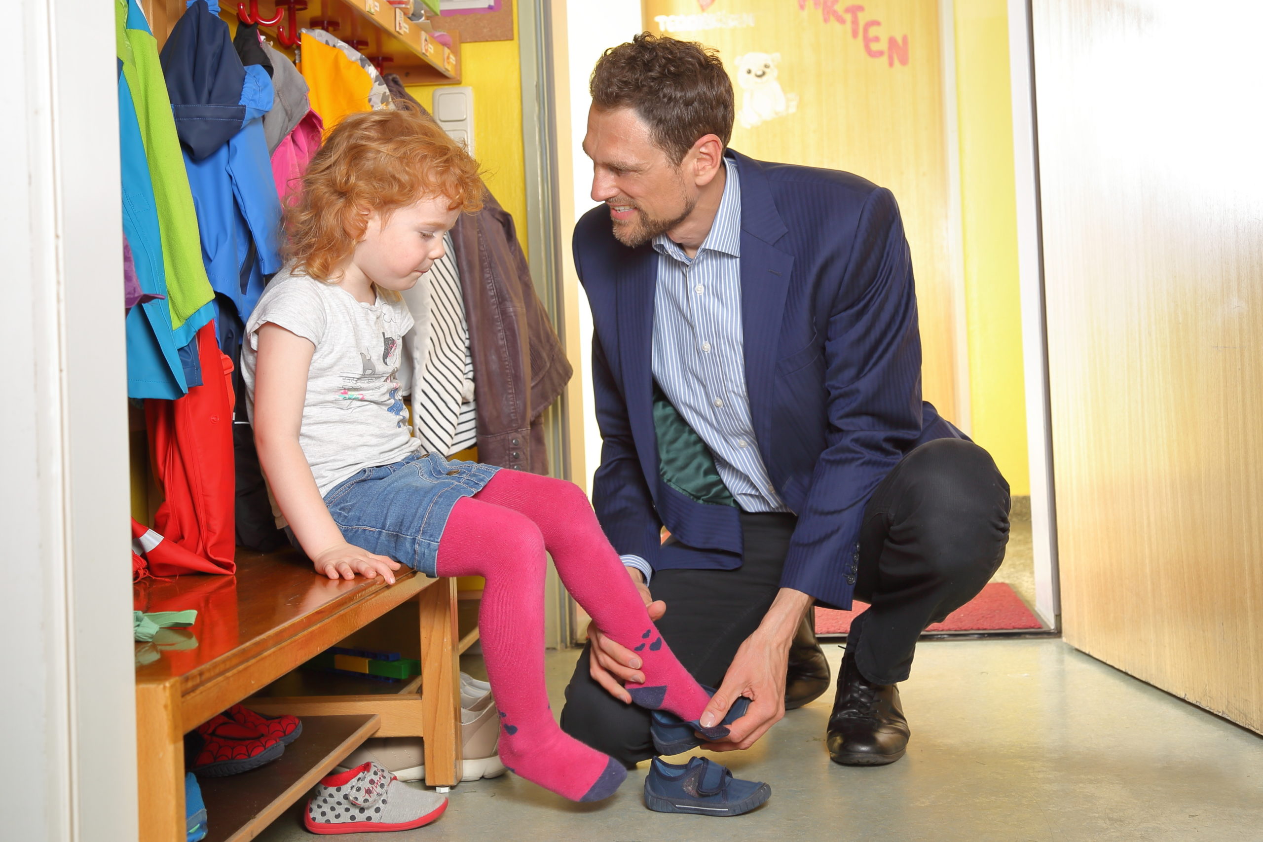 A father picks up his child in nursery